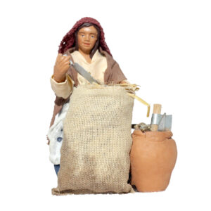 Donna Seduta con Sacco Paglia e Attrezzi